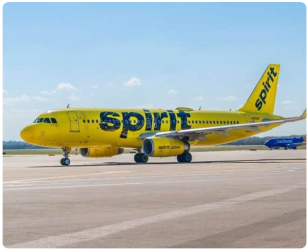 Yellow Spirit Airlines jet parked on the tarmac at the airport, facing left