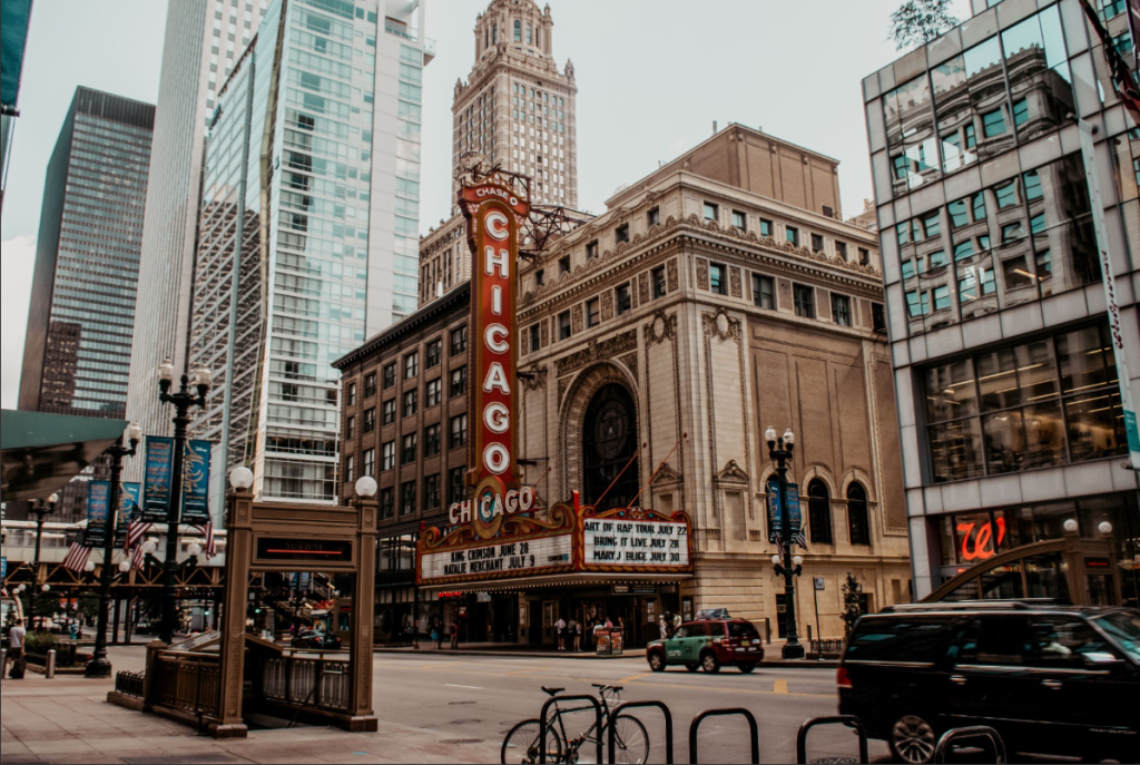 Vertical Chicago Sign on the Chicago Theatre Marquee Along a Busy Downtown Street with Modern Glass Buildings Nearby. (informative: Identifies the Theater and Location/context) Vertical Chicago Sign on the Chicago Theatre Marquee Along a Busy Downtown Street with Modern Glass Buildings Nearby. (informative: Identifies the Theater and Location/context)